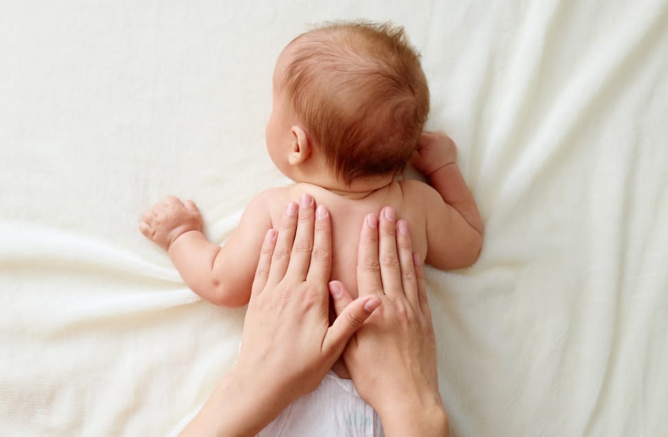 Frauen Hände massieren Baby am Rücken