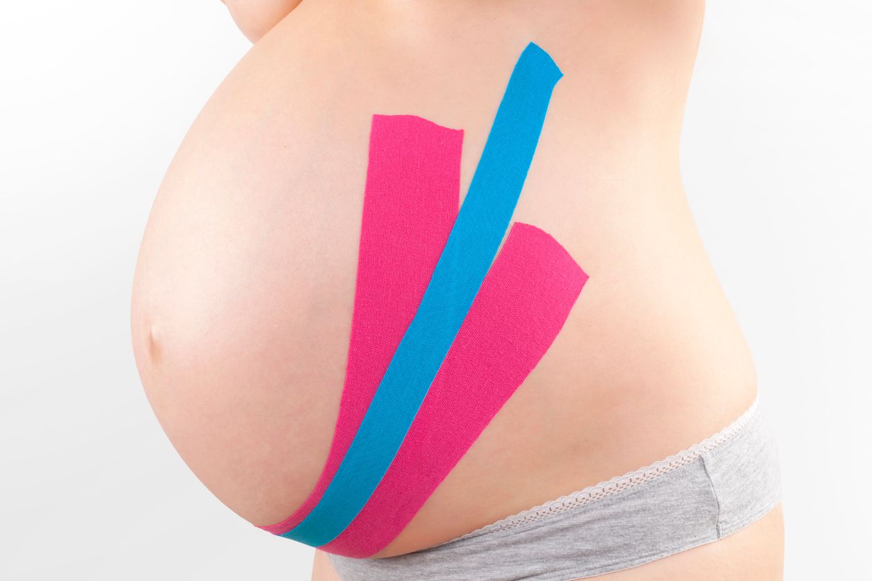 Taping am Babybauch einer schwangeren Frau